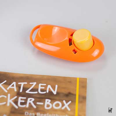 Orangefarbener Clicker mit gelbem Knopf