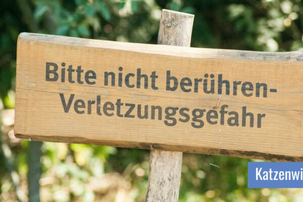 Holzschild mit der Aufschrift "Bitte nicht berühren - Verletzungsgefahr"